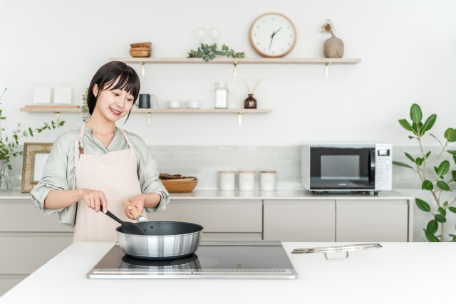 高さ90cmのキッチンで背筋を伸ばして料理をする女性