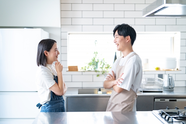 リフォーム後のキッチンで向かい合って話す夫婦