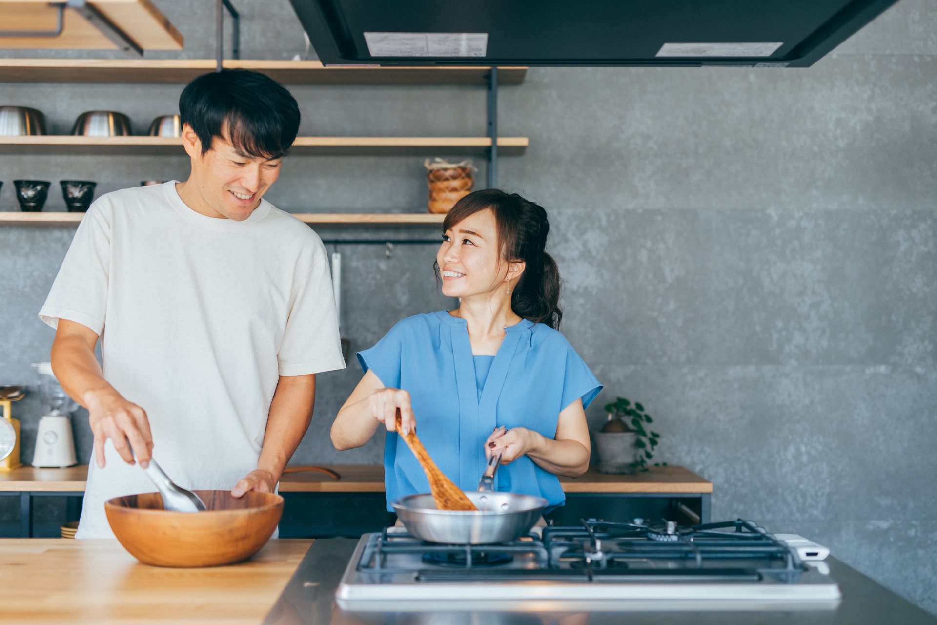 夫婦でガスコンロを使って料理をするキッチン。天板の高さは二人で使うことを考えて選ぶ