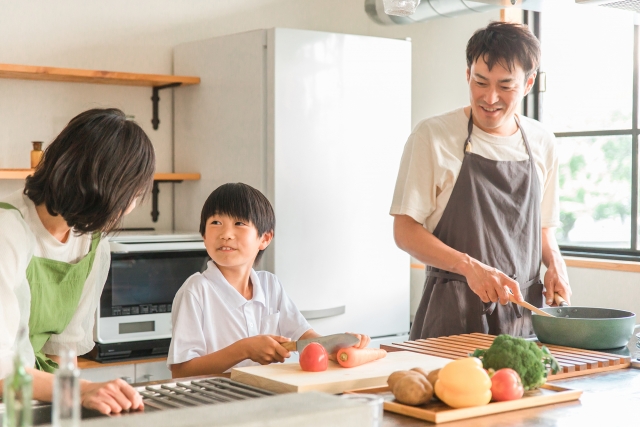 子どもと一緒に料理をする家族。子育て中は低めのキッチンが向くこともある