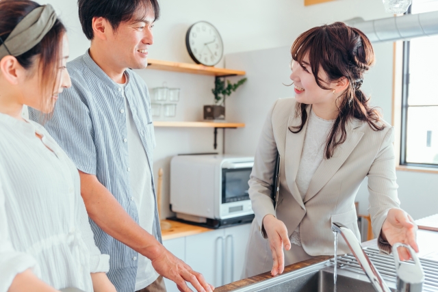 ショールームでスタッフからシンクの説明を受ける夫婦