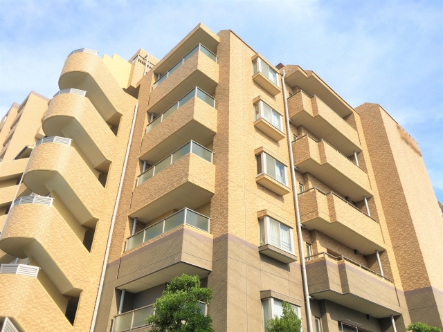 青空を背景にした分譲マンションの外観
