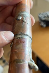 銅製の給湯管のつなぎ目。ろう付けされた継手が3か所並んでいる